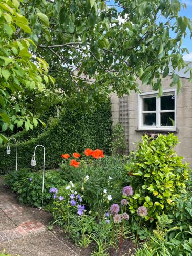 a garden with flowers in front of a house at LOGIES Tuin der Zinnen in Rijkevorsel