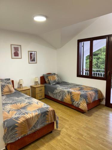 a bedroom with two beds and a window at Savo Apartments in Tivat