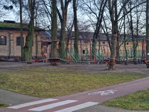 a park with a playground with trees and benches at Apartament w Centrum in Kętrzyn