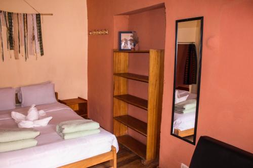 a room with a bed and a mirror at Loki Cusco in Cusco