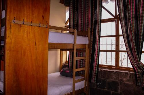 a bedroom with two bunk beds and a window at Loki Cusco in Cusco
