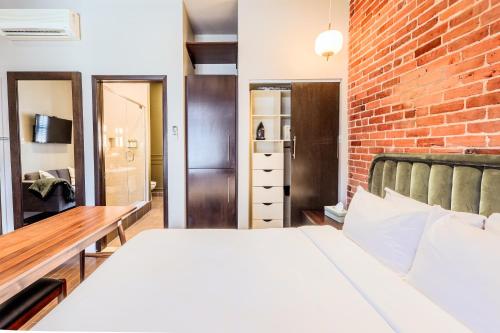 a bedroom with a bed and a brick wall at Self Check-In Boutique Hotel - Quartier latin - Room 101 in Montréal