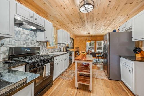 a kitchen with white cabinets and a wooden ceiling at Downtown Mentone - Baileys Bungalow in Mentone