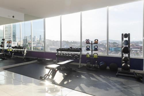 a gym with large windows and a view of a city at The Sands Apartments By Acomodo in Panama City