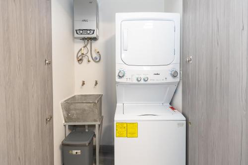 a small kitchen with a washing machine and a window at The Sands Apartments By Acomodo in Panama City