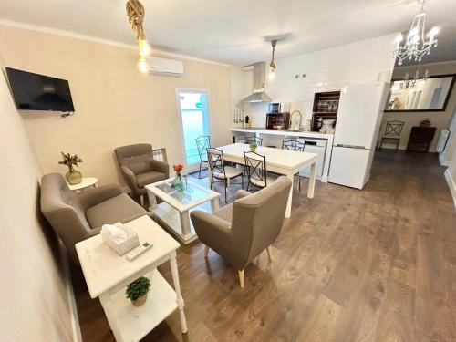 Una sala de estar con mesa y sillas y una cocina. en el piso del patio chico, en Ávila
