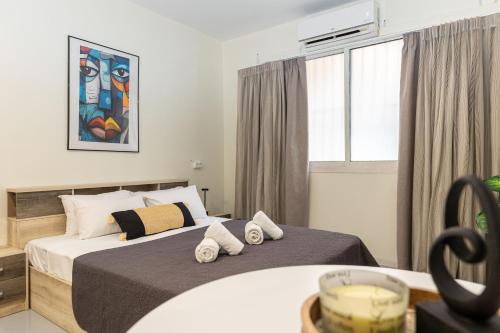 Un dormitorio con dos camas y una mesa y una ventana. en Nobia 3, en Atenas