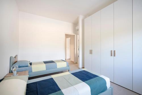 two beds in a bedroom with white cabinets at GuestHost - Oasi Monticelli in Polignano a Mare