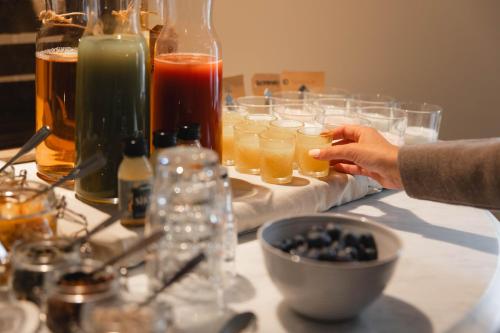 a table with glasses of drinks and a persons hand at Villa Gutebagge Hotell in Visby