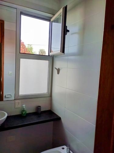 a bathroom with a toilet and a window at Casa en Zona Parque San Carlos in Concordia