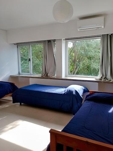 a bedroom with two beds and two windows at Casa en Zona Parque San Carlos in Concordia