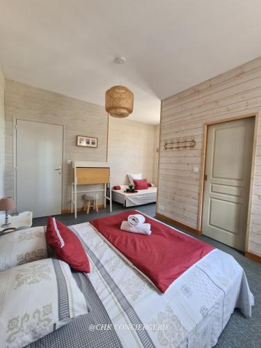 a bedroom with a large bed with a red blanket at Dors Fée Duplex avec Toit-Terrasse et Salle de Jeux - Centre Bourg à 4 min du Puy duFou in Les Épesses