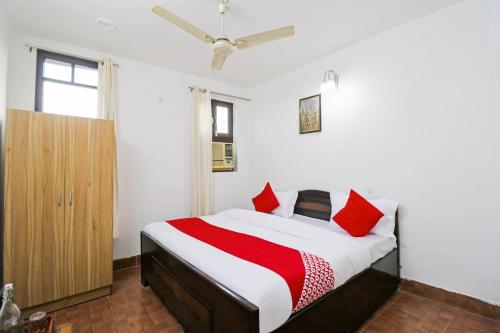 a bedroom with a bed with red pillows at Hotel O Cloud Stay & Cafe in Indraprast