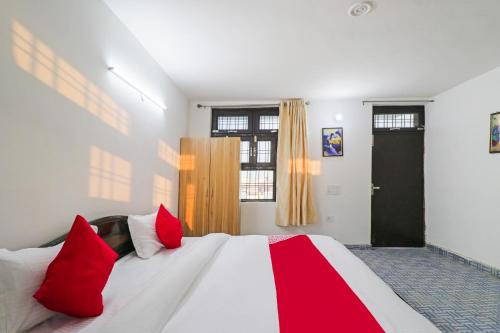 a bedroom with a large bed with red pillows at Hotel O Cloud Stay & Cafe in Indraprast