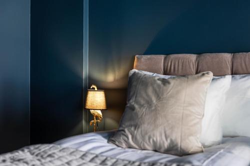 a bed with a pillow and a lamp next to it at Villa Gutebagge Hotell in Visby
