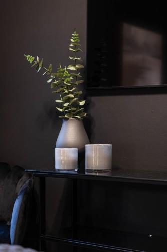 a plant in a vase on a table with candles at Villa Gutebagge Hotell in Visby