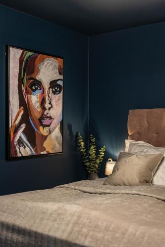 a bedroom with a painting of a black woman at Villa Gutebagge Hotell in Visby