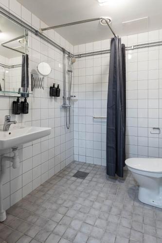 a bathroom with a sink and a toilet at Villa Gutebagge Hotell in Visby