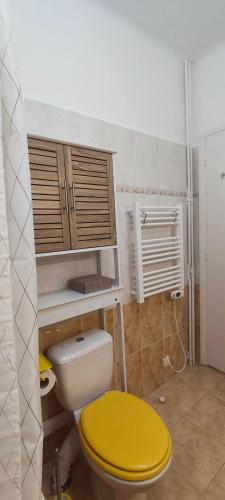 La salle de bains est pourvue de toilettes et d'un couvercle jaune. dans l'établissement Nice Ouest, studio apartment near the beach, à Nice