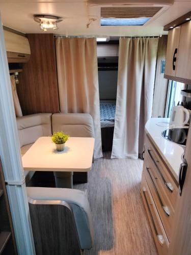 a small table in an rv kitchen with a table and chairs at Camping Park and SPA Katowice in Katowice