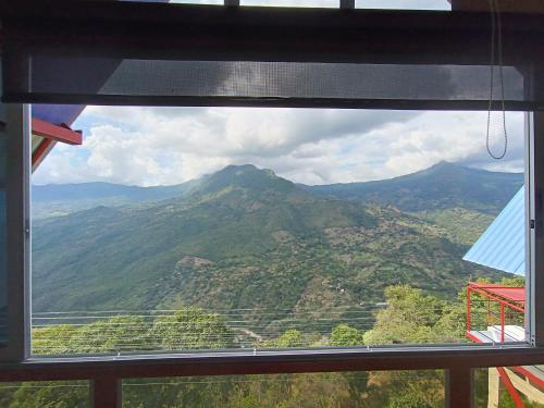 a view of a mountain through a window at HCR Hotel y Centro de Convenciones Chinauta Real in Fusagasuga
