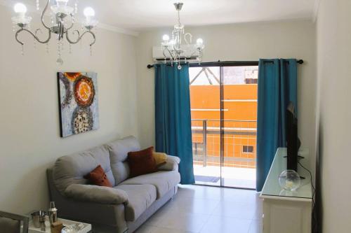 a living room with a couch and a sliding glass door at Spacious Two Bedroom Two Bathroom Apartment in Downtown Asuncion in Caña de Castilla