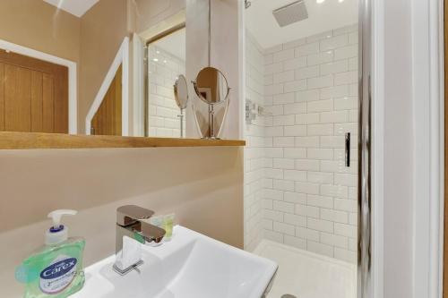 a white bathroom with a sink and a mirror at Bantham Mews by Pureserviced 1 bedroom luxury mews in Plymouth