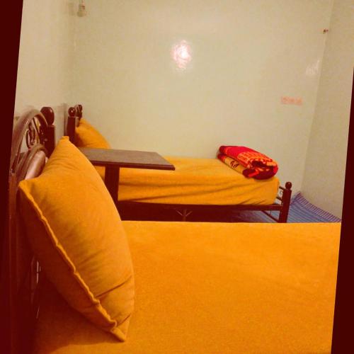 a small room with a bed and a table at Riad Dar Amgdoule Tacheddirt in Tacheddirt