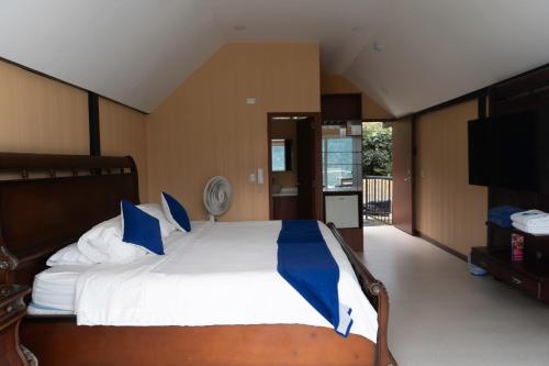 a bedroom with a bed with blue and white pillows at HCR Hotel y Centro de Convenciones Chinauta Real in Fusagasuga