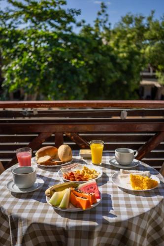 a table with plates of food on a checkered table cloth at Suítes Pe na Areia in Jericoacoara