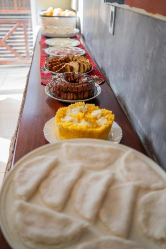 a table topped with plates of pies and pastries at Suítes Pe na Areia in Jericoacoara
