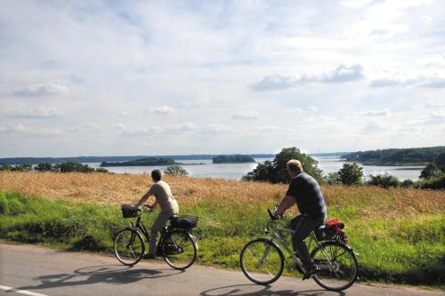 two men riding their bikes down a road at Ostsee-Strandhaus-Holnis in Glücksburg