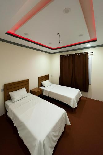 two beds in a room with a red ceiling at Aba-SHAH GUEST HOUSE SKARDU in Skardu