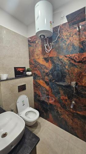 a bathroom with a toilet and a sink at Aalaya By Karamya Homes in Rishīkesh