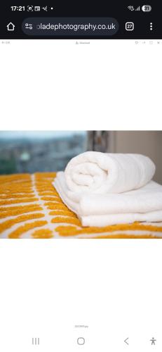 una pila de toallas blancas sentadas sobre una mesa en Dreaminstyle the Gatehaus, en Bradford