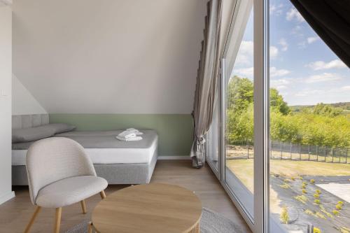 a bedroom with a bed and a table and a window at Raduńskie Zacisze in Chmielno