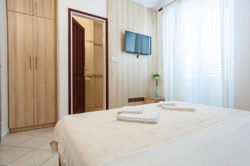 a bedroom with a bed with two towels on it at Vila Mitrovic in Budva