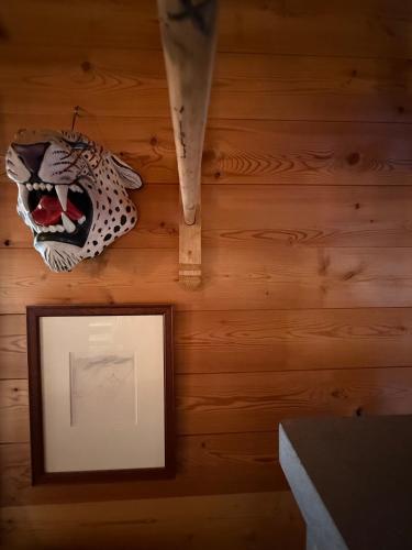 a framed picture and a mask hanging on a wall at Grange de Fonville - Evolène - Valais in Evolène
