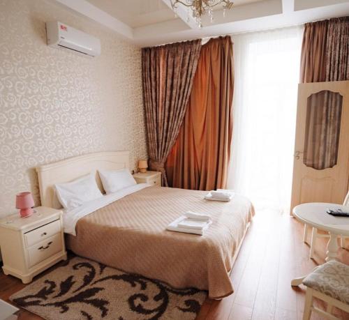 a bedroom with a bed and a table and a window at Apartment on Sumskaya 46 "Central Residence" in Kharkiv
