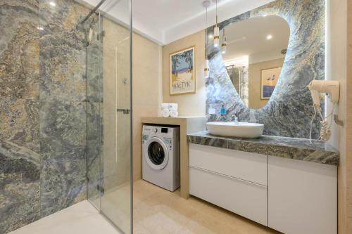 un bagno con lavandino e lavatrice di Słoneczna 10a w Jarosławcu Apartamenty nad morzem a Jarosławiec