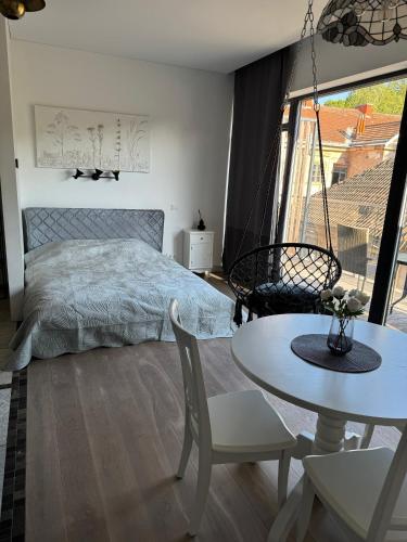 a bedroom with a bed and a table at Cozy Apartment in Vilnius Paupys in Vilnius