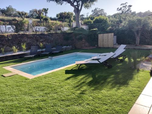 - une piscine dans une cour avec des chaises et une table dans l'établissement Villa la CROIX VALMER vue panoramique avec piscine, à La Croix-Valmer