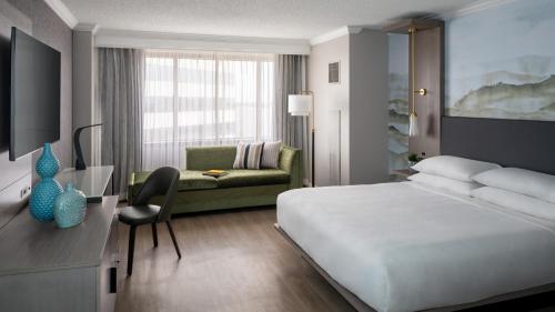 a hotel room with a bed and a couch at Marriott Jacksonville Downtown in Jacksonville