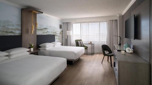 a hotel room with two beds and a desk at Marriott Jacksonville Downtown in Jacksonville