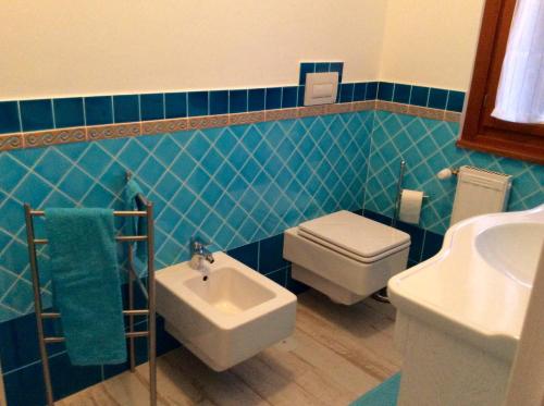 a blue tiled bathroom with a toilet and a sink at Villa Nia affittacamere in Palestrina
