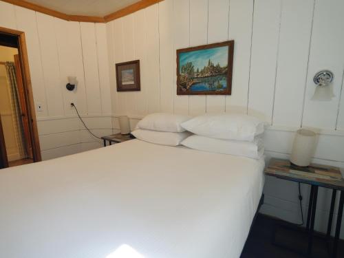 a bedroom with a bed with white sheets at Lake Front Cabins in June Lake