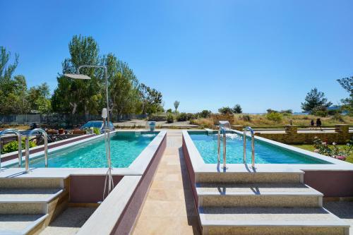 a swimming pool with steps and a swimming poolvisorvisor at Golden Sunrise Apartments in Chrysi Ammoudia
