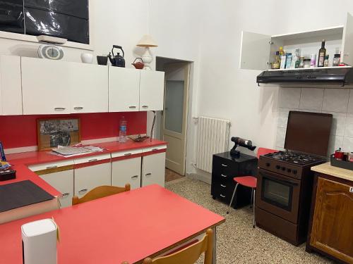 una cucina con banconi rossi e un tavolo rosso al suo interno di Casa Rella - Camera Green a Bologna