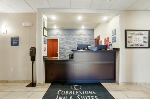 a lobby with a reception desk in a building at Cobblestone Hotel & Suites - Russells Point at Indian Lake in Russells Point