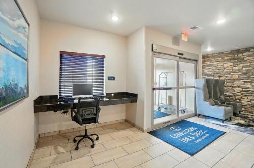 a office with a desk with a computer and a chair at Cobblestone Hotel & Suites - Russells Point at Indian Lake in Russells Point